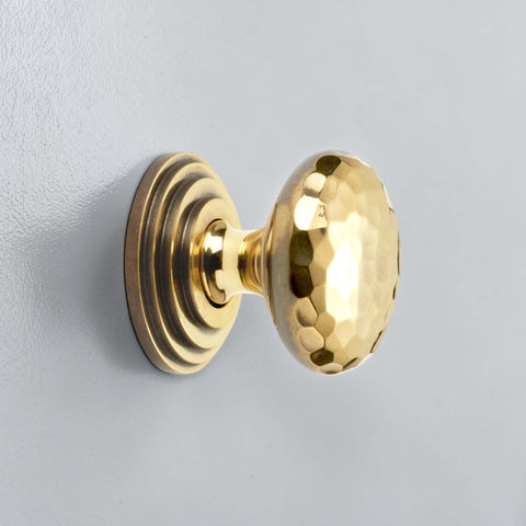 38mm solid aged brass hammered cupboard knob with stepped backplate fitted to grey cabinet door