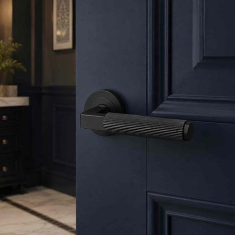 Matt black reeded lever door handle on a navy blue panelled door, showcasing the minimalist square neck design.