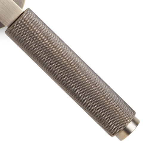 Close-up detail of knurled grip on matt antique brass lever door handle