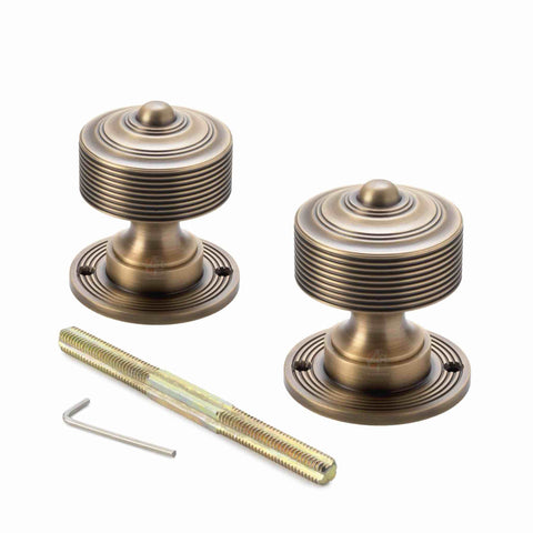Pair of matt antique brass reeded door knobs with backplates, threaded spindle and Allen key