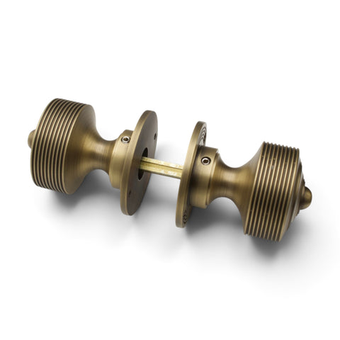 Matt antique brass reeded rim and mortice door knob pair connected with square spindle