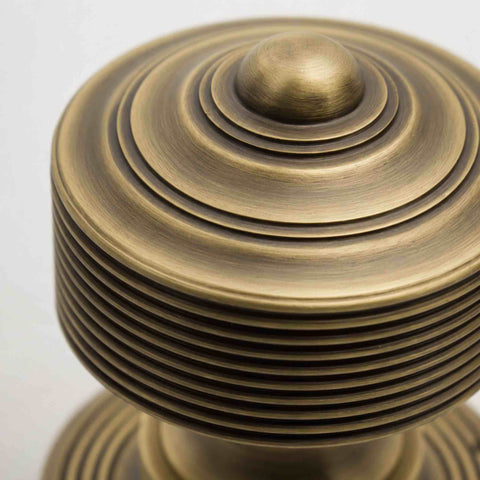 Close-up of matt antique brass reeded door knob showing concentric detailing and brushed finish