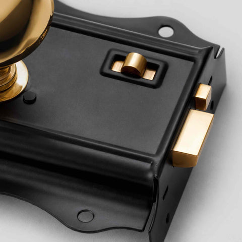 Detailed View of Solid Brass Mushroom Door Knob Mounted on Black Rim Lock Body
