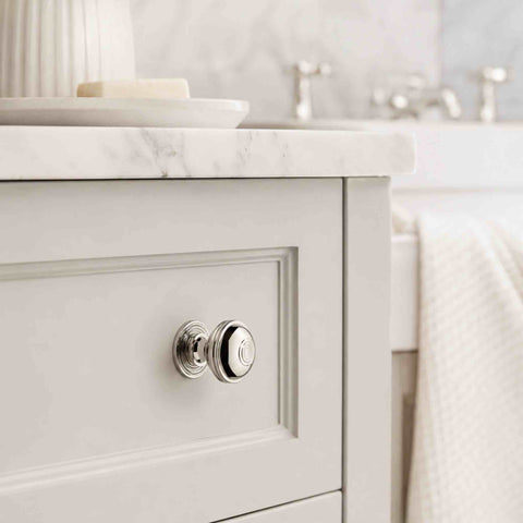 Polished nickel Bloxwich cupboard knob fitted to a white shaker-style bathroom vanity drawer, adding a classic finishing touch.