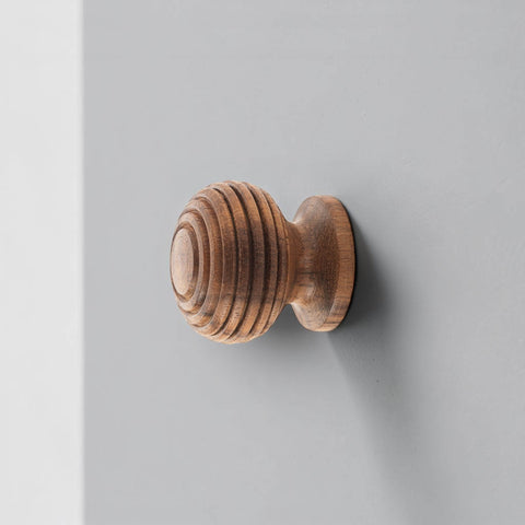 Rosewood beehive cupboard knob fitted to grey cabinet door side profile