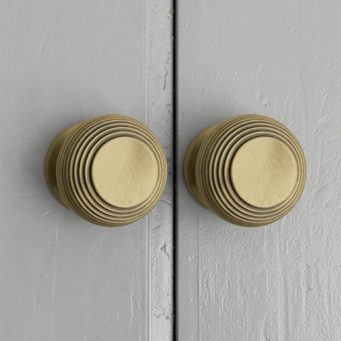 Pair of Antique Brass Beehive Cupboard Knobs Fitted on Grey Cabinet Doors