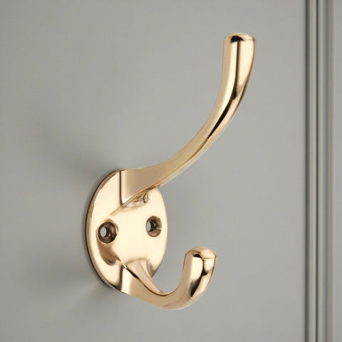 Polished brass Victorian style double coat hook fitted to painted door panel