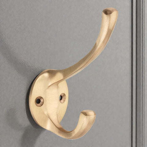 Satin brass Victorian coat hook fitted to door with dual hook design and round backplate