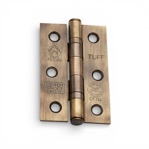 Single antique brass CE7 ball bearing butt hinge with CE and fire certification markings on a white background