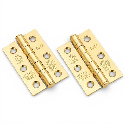Pair of polished brass CE7 ball bearing butt hinges, fire rated, showing both hinges at an angle on a white background
