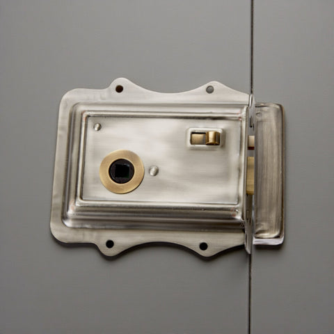 Close-up of Olde Victorian rim lock in pewter finish with antique brass snib and detailing