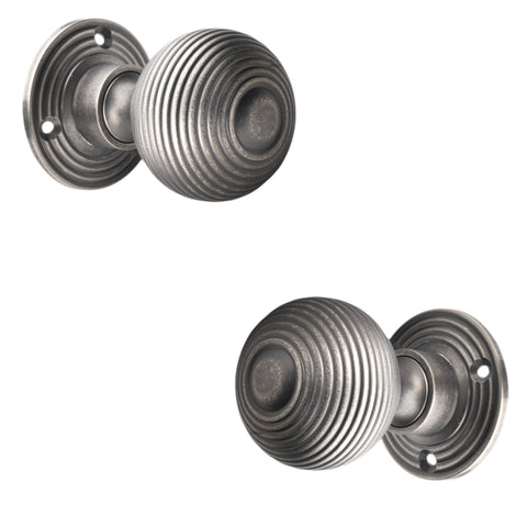 Angled front and rear view of pewter reeded beehive mortice door knobs.