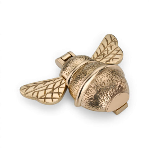 Unlacquered polished brass bumble bee door knocker, angled side view showing textured body and striking mechanism.