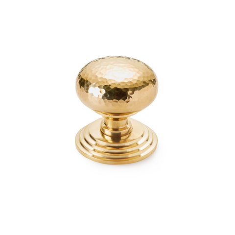 Hammered polished brass cottage centre door knob with stepped backplate, angled front view on white background