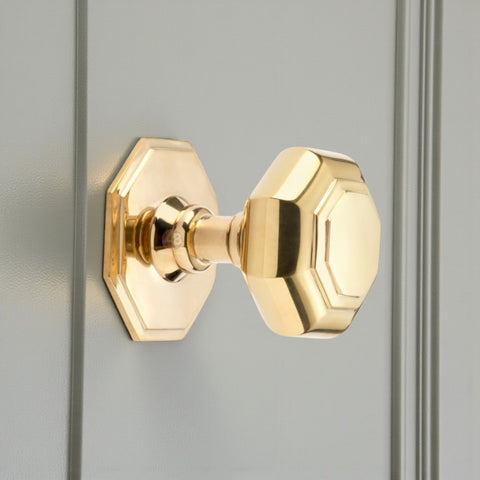 Polished Brass Octagonal Centre Door Knob on grey door.