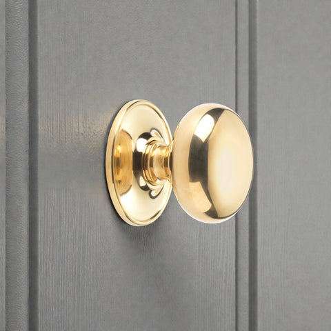 Polished brass cottage centre door knob fitted to painted internal door