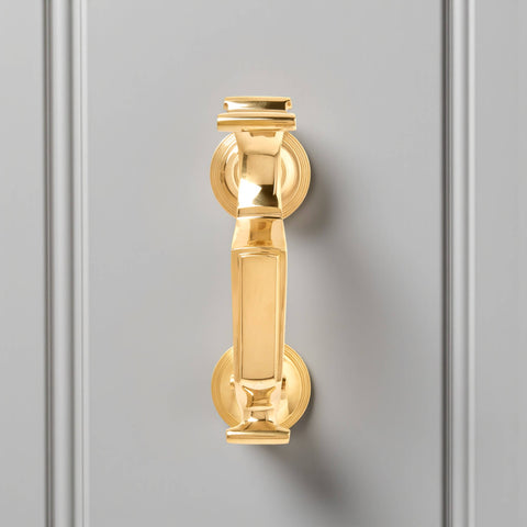 Unlacquered polished brass reeded doctor door knocker front view showing solid brass backplates