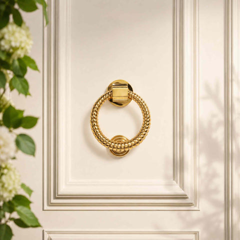 Polished brass reeded ring door knocker fitted to a traditional dark front door