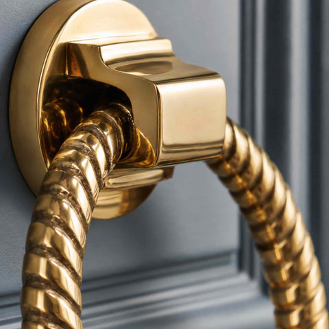 Polished brass reeded ring door knocker mounted on a cream panelled entrance door
