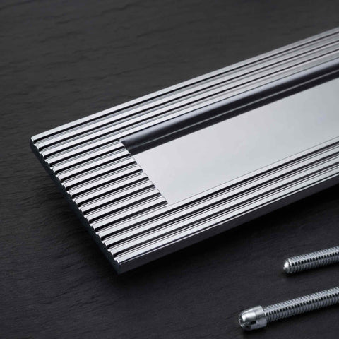 Close-up of polished chrome reeded detailing and plain sprung flap letter box plate