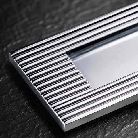 Detailed corner view of polished chrome reeded frame on solid brass letter plate