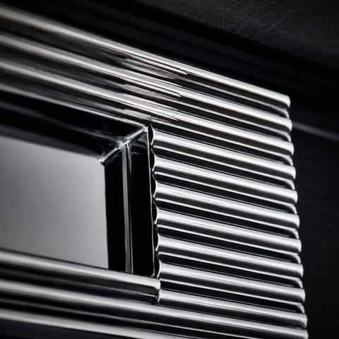 Macro close-up of polished chrome reeded detailing and sprung flap mechanism on letter box plate