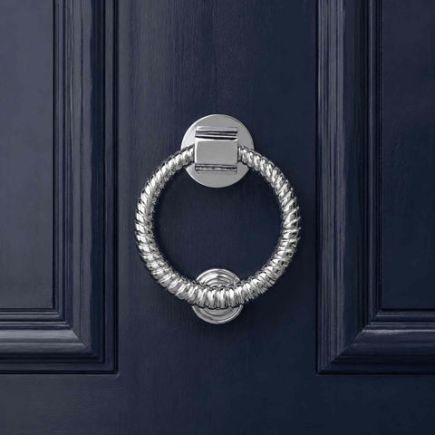 Polished chrome reeded ring door knocker fitted to a dark blue entrance door
