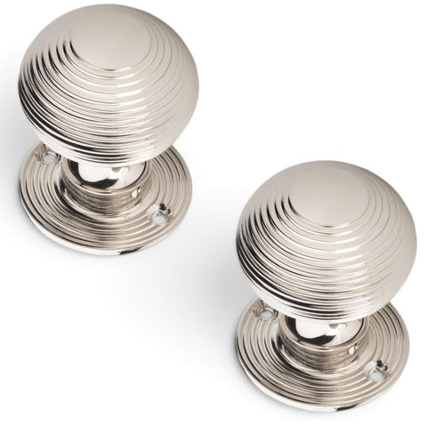 Pair of polished nickel reeded beehive door knobs shown from angled top view with decorative reeded backplates