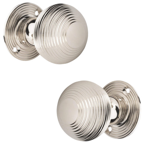 Pair of polished nickel reeded mortice door knobs shown from side profile angle on white background