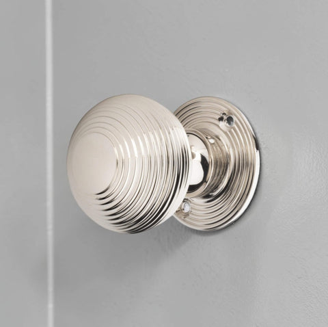 Polished nickel reeded beehive mortice door knob installed on painted grey wooden door