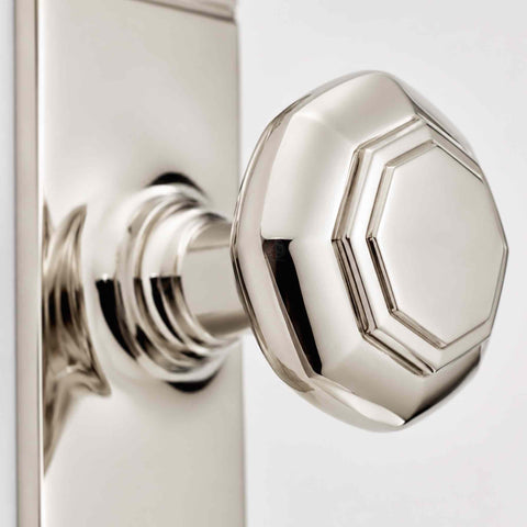 Close-up of polished nickel octagonal door knob showing detailed stepped face and reflective finish