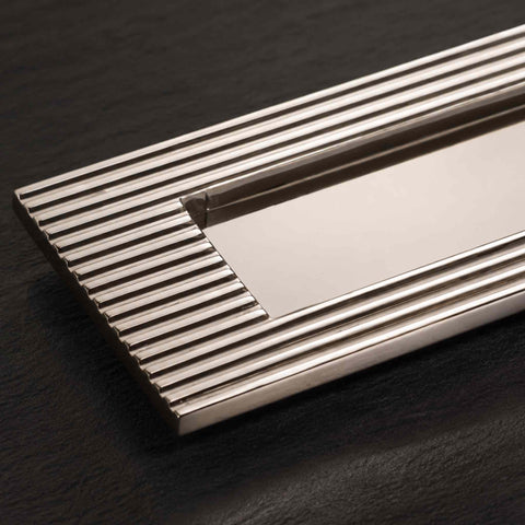 Close-up of polished nickel reeded detailing and plain sprung flap letter box plate