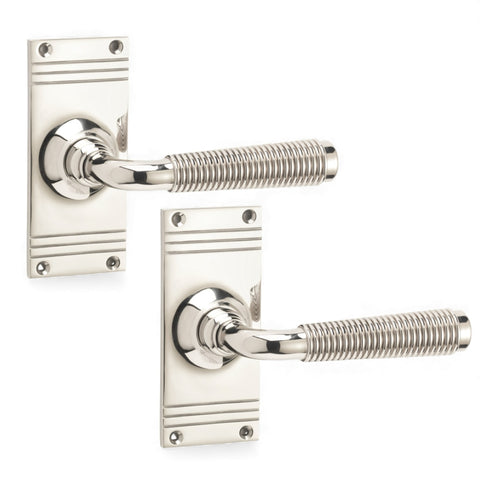 Polished nickel reeded lever on rectangular backplate door handle pair on white background