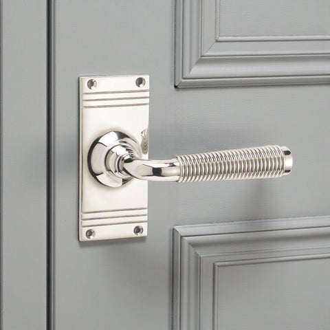 Polished nickel reeded lever on backplate door handle fitted to grey panelled door