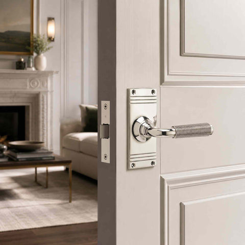 Polished nickel reeded lever door handle fitted to a white panelled interior door, demonstrating the elegant finish and traditional styling.