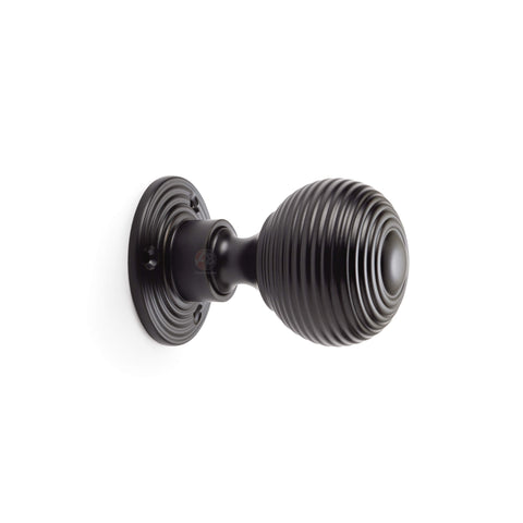 Side profile powder coated black reeded beehive rim mortice door knob on round rose backplate.