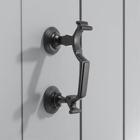 Powder coated black reeded doctor door knocker mounted on grey door, angled side view showing circular backplates and solid brass construction.
