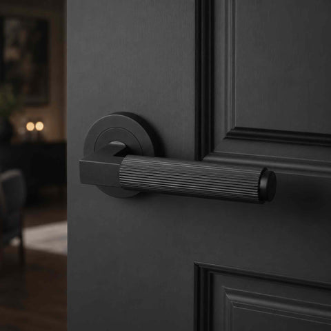 Modern black reeded lever handle mounted on a round rose, installed on a dark interior door with luxury contemporary room setting.