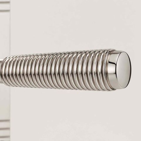 Macro close-up of the polished nickel reeded grip showing the precision-machined texture and polished end cap.