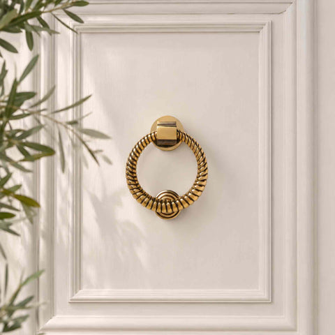 Aged brass reeded ring door knocker fitted to a cream front door