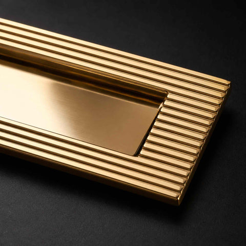 Detailed view of the reeded border and polished brass finish on a solid brass letter plate