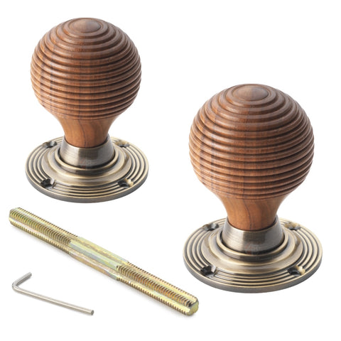 Pair of rosewood beehive door knobs with antique brass roses and fixing kit.