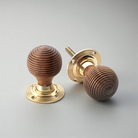 Pair of rosewood polished brass beehive door knobs with spindle bar