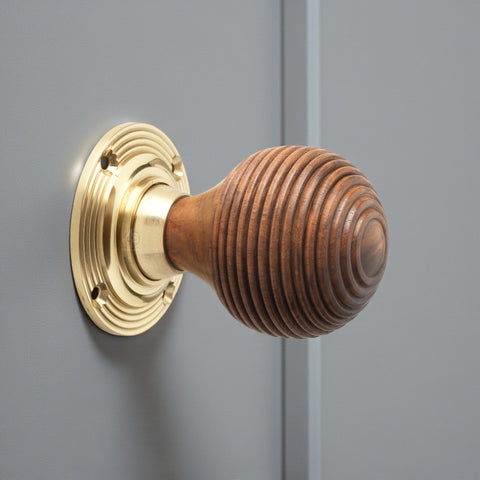 Rosewood beehive door knob fitted on grey door with polished brass rose plate