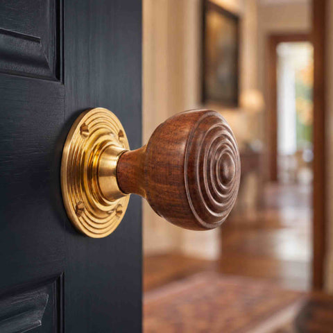 Rosewood and unlacquered polished brass ringed door knob fitted to a dark blue panelled interior door