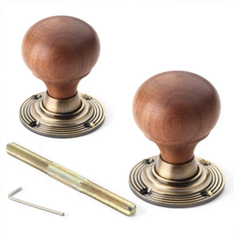 Pair of rosewood bun door knobs with antique brass backplates, spindle and fixing key