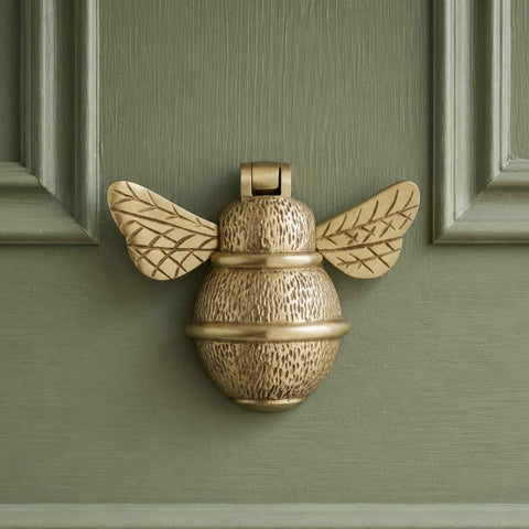 Front view of satin brass bumble bee door knocker fitted to a panelled exterior door