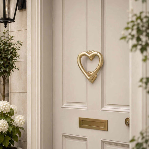 Satin Brass Heart Door Knocker Installed on a Light Grey Front Door with Matching Letter Plate