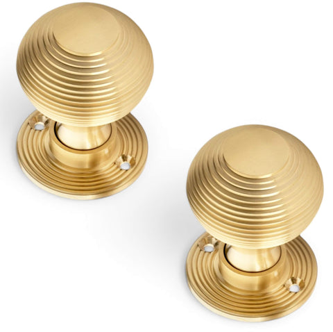 Pair of satin brass Victorian beehive door knobs with traditional reeded design and round backplates