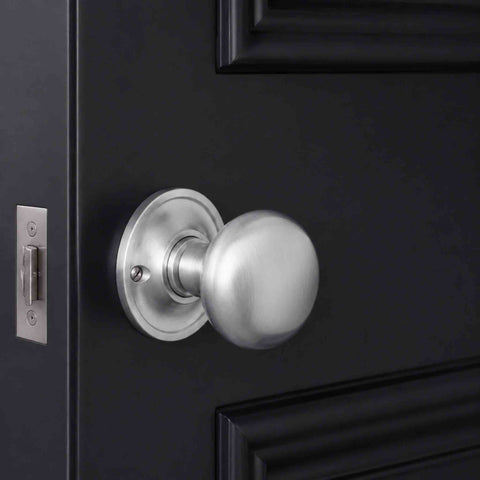Satin chrome mushroom cottage door knob fitted to a black panelled internal door with matching tubular latch.